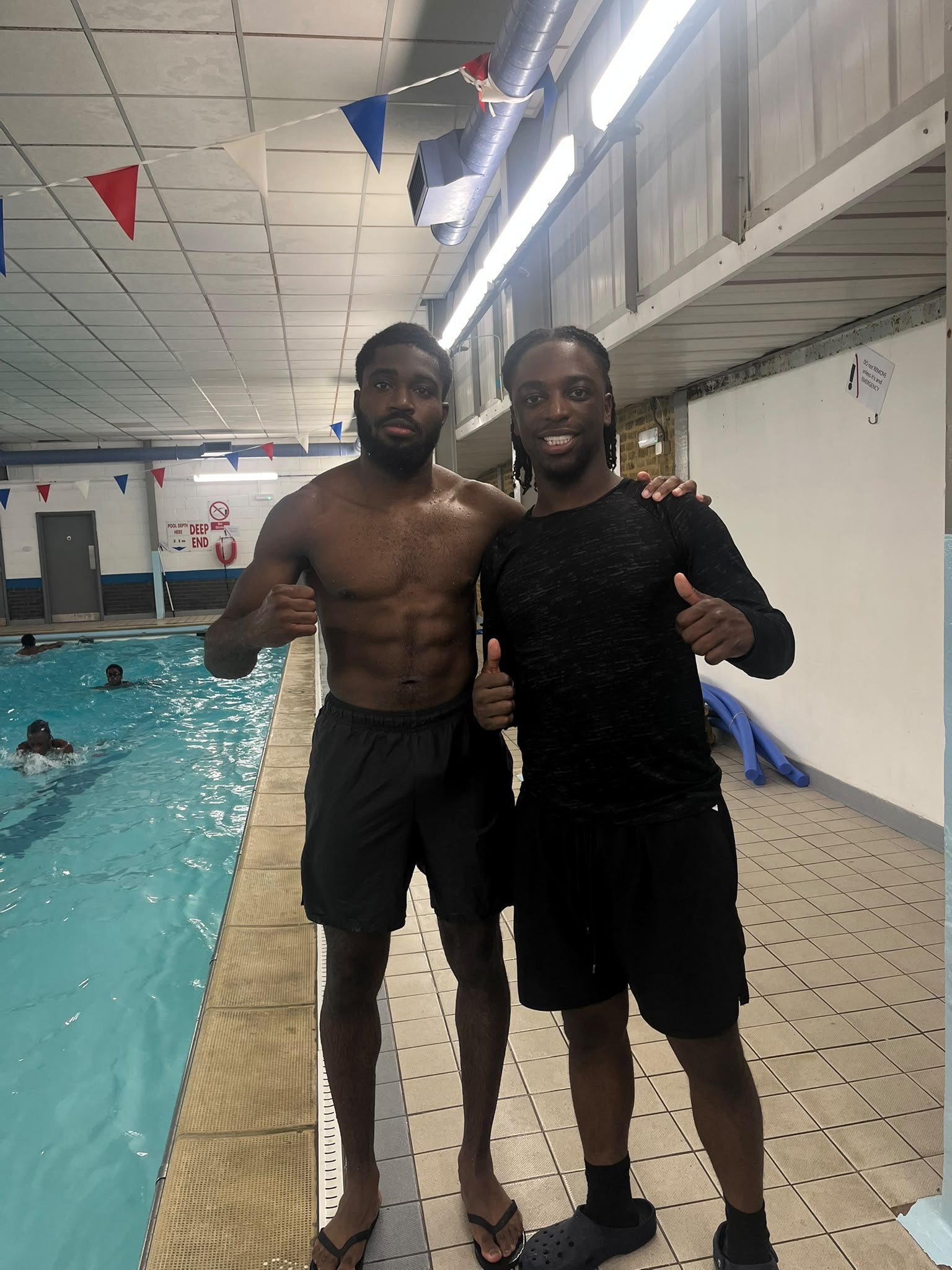 Aqua Jetz instructor Adriel celebrating poolside with an adult swimming student