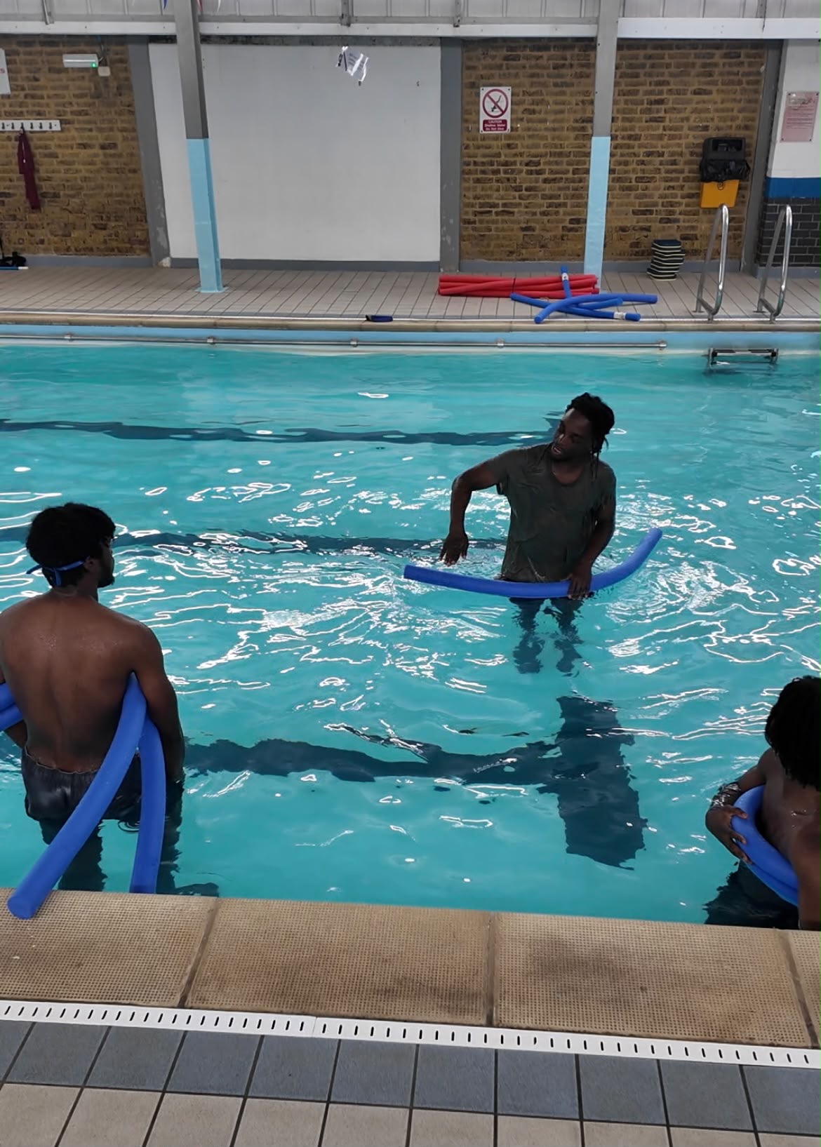 Aqua Jetz instructor supporting learners with pool noodles on water safety skills